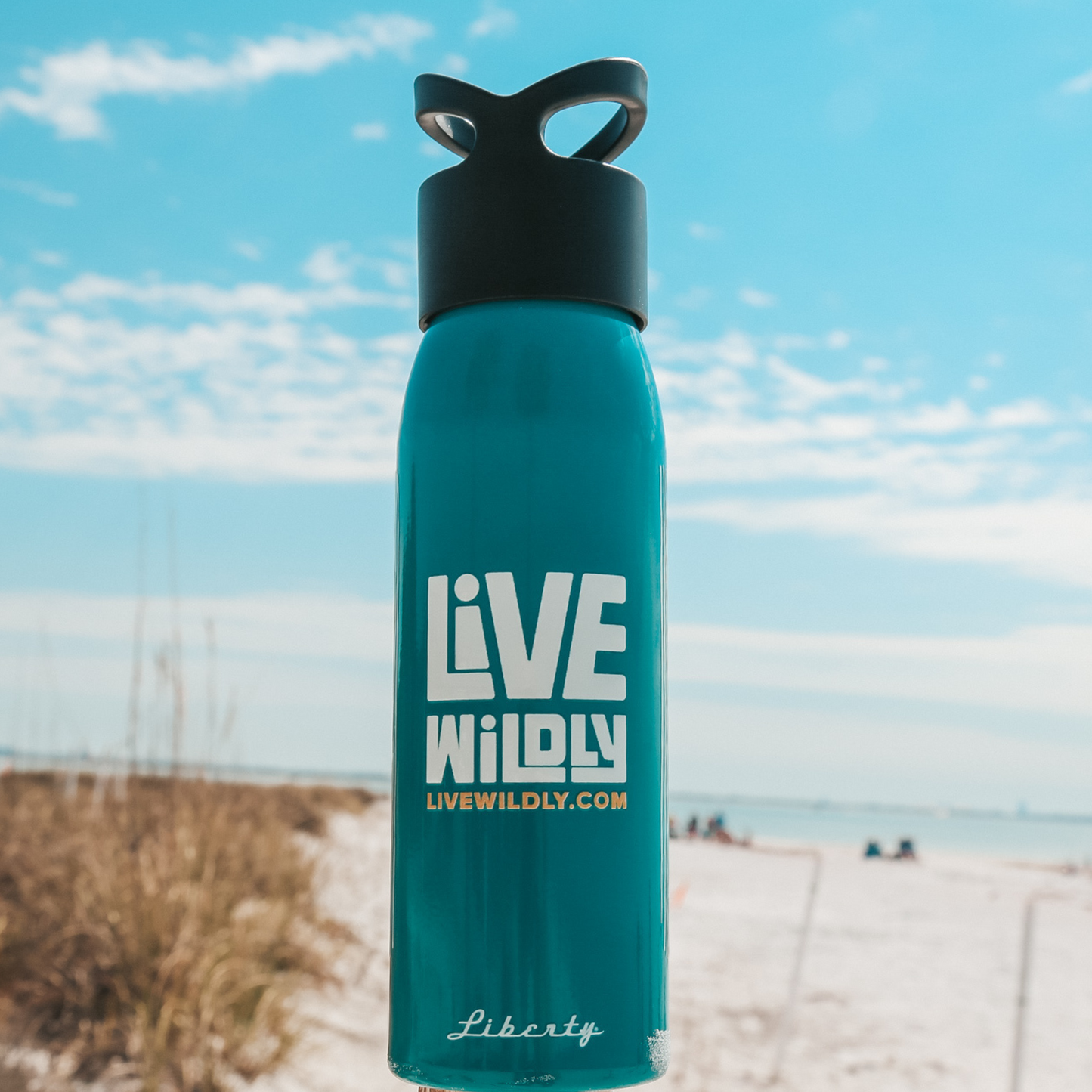 Live Wildly Recycled Water Bottle - Teal - On Beach - Live Wildly 
