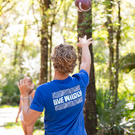 Load image into Gallery viewer, Live Wildly Unisex Tee – Royal  On Athlete Throwing -- Live Wildly 
